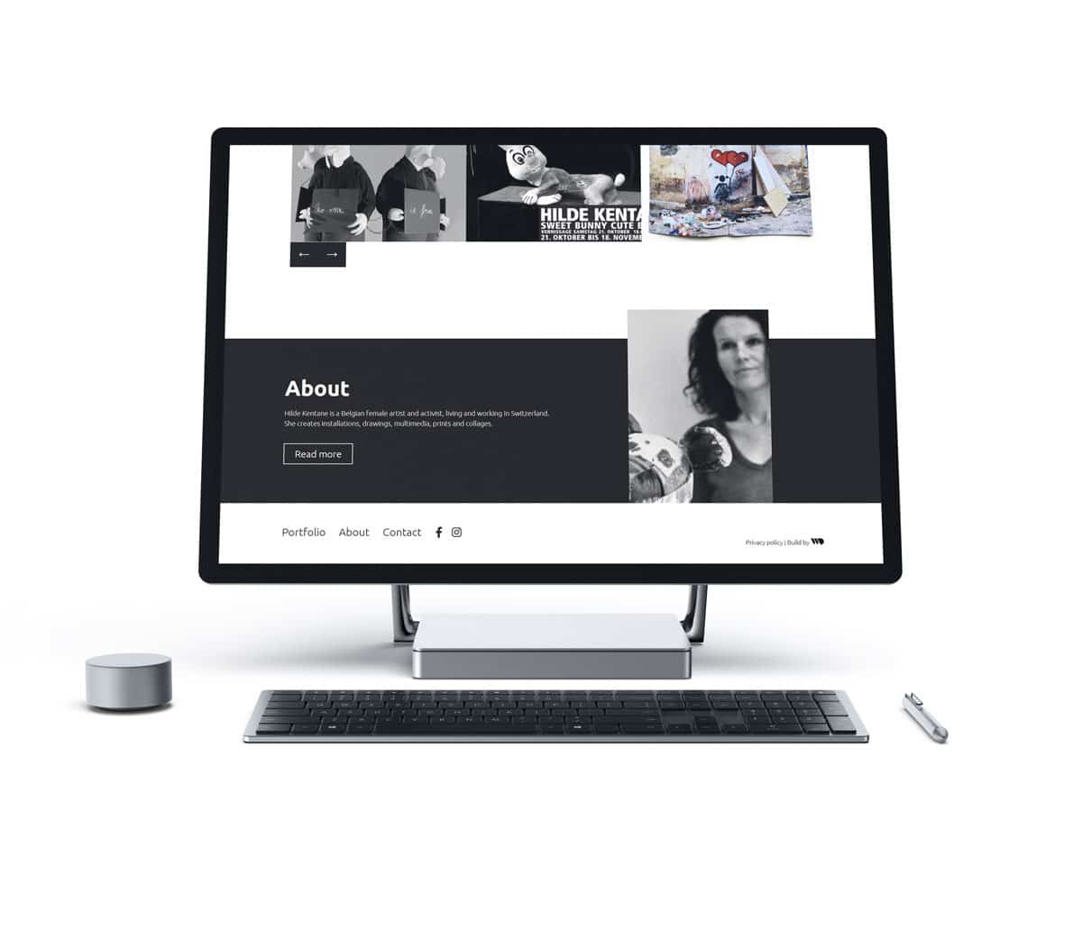 Minimalistisch ontworpen monitor die de 'About' pagina van kunstenares Hilde Kentane weergeeft, met zwart-wit foto's van haar werken en een portret, tegen een cleane witte achtergrond, reflecterend haar artistieke stijl.