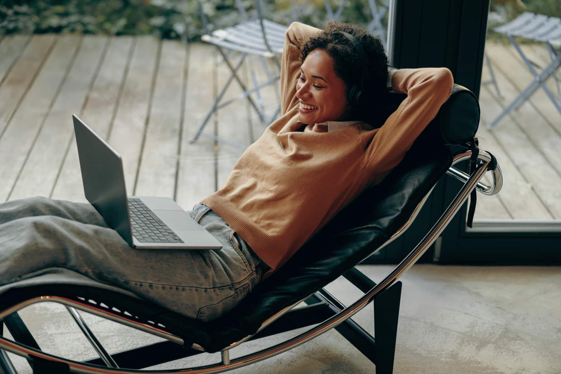 Vrouw ontspannen met een laptop op haar schoot, genietend van het gemak van e-mailautomatisering.