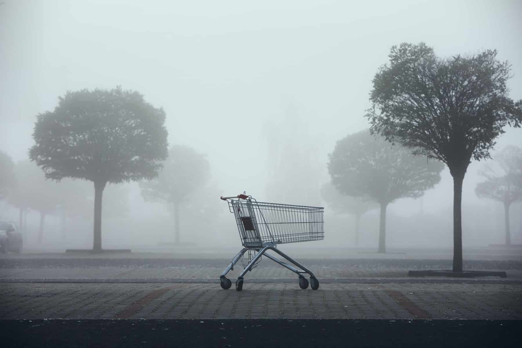 een verlaten winkelmandje op een mistige parkeerplaats, een visuele metafoor voor gemiste kansen zonder effectieve e-mailautomatiseringen in je marketingstrategie.